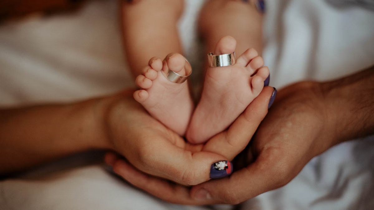 A baby's feet gently held by parents' hands, symbolizing love and care.